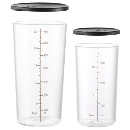 Das Unold ESGE-Zauberstab Becherset-Glas umfasst zwei klare, zylindrische Glasbehälter mit schwarzem Deckel und Maßangaben in ml und fl oz – einer fasst 700 ml und der andere 300 ml.