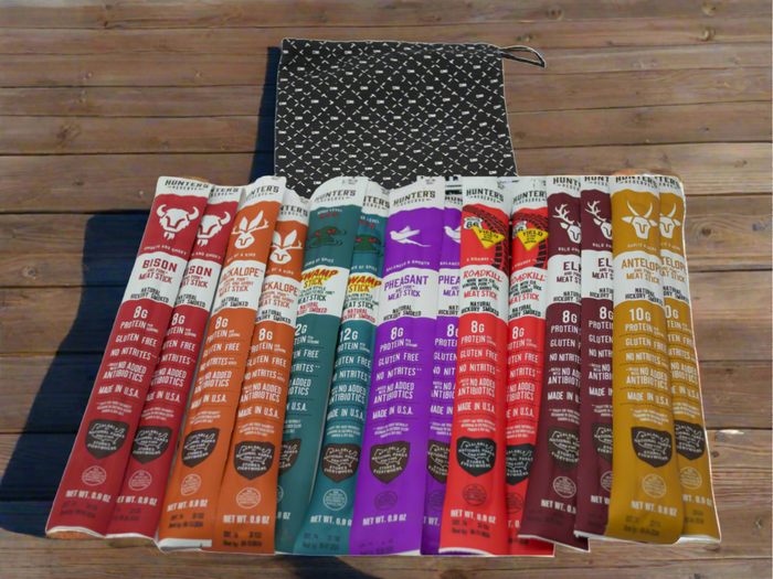 Exotic Meat Sticks Bag with 14 wild beef jerky snacks in various flavors, displayed in front of a reusable canvas bag.