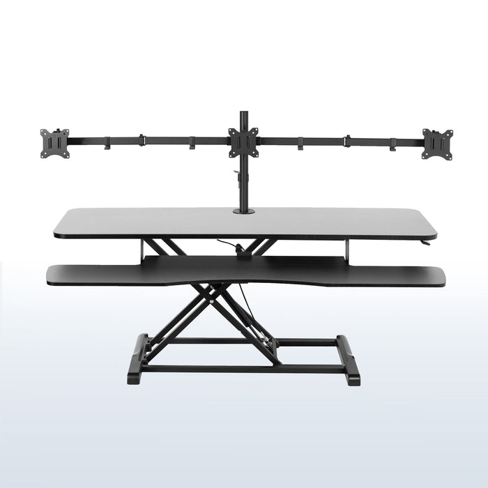 Spacious height adjustable desk riser with articulating triple monitor mount.