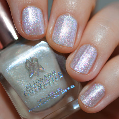 Close-up of nails painted with Spirit Nail Lacquer on fair skin tone. Hand is holding polish bottle.