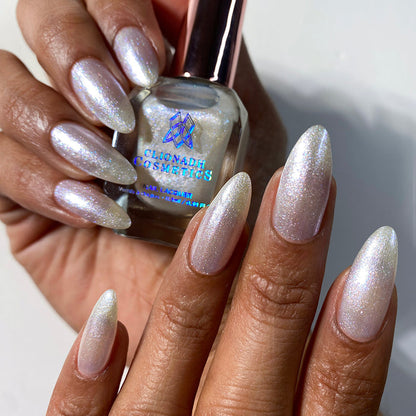 Nails painted with Spirit Nail Lacquer on medium skin tone. Hand is holding polish bottle.