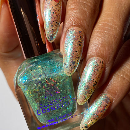 Close-up of nails painted with Fauxjito Nail Lacquer on medium skin tone. Hand is holding polish bottle.
