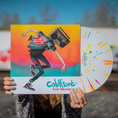 Someone holds a limited edition Coldfront "Float Around" vinyl—white with red, yellow, and blue splatter—with cover art of a dancing boombox-headed character. Blurred background and blue-painted nails draw focus to the vibrant album.