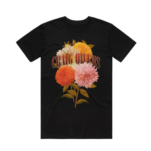 A black Craig Owens Comfort Colors T-shirt with a bold, retro “CRAG QUEENS” print over a vibrant bouquet of orange, yellow, pink, and white dahlias—a must-have floral tee for climbing fans.