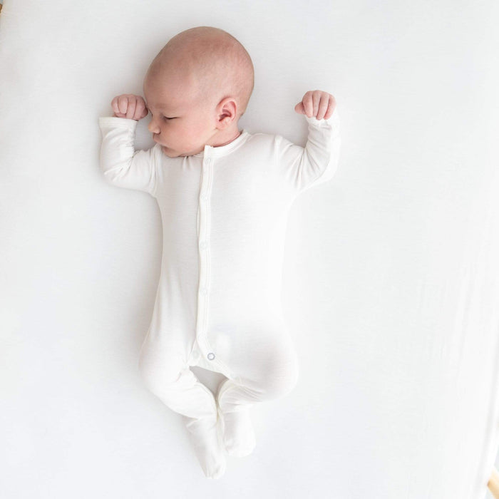 Sleeping infant wearing  Kyte Baby Snap Footie in Cloud