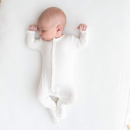 Sleeping infant wearing  Kyte Baby Snap Footie in Cloud