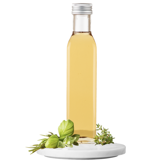 A bottle of Garden Herb Vinegar with a white label and a small green herb sprig on top, set against a transparent background.