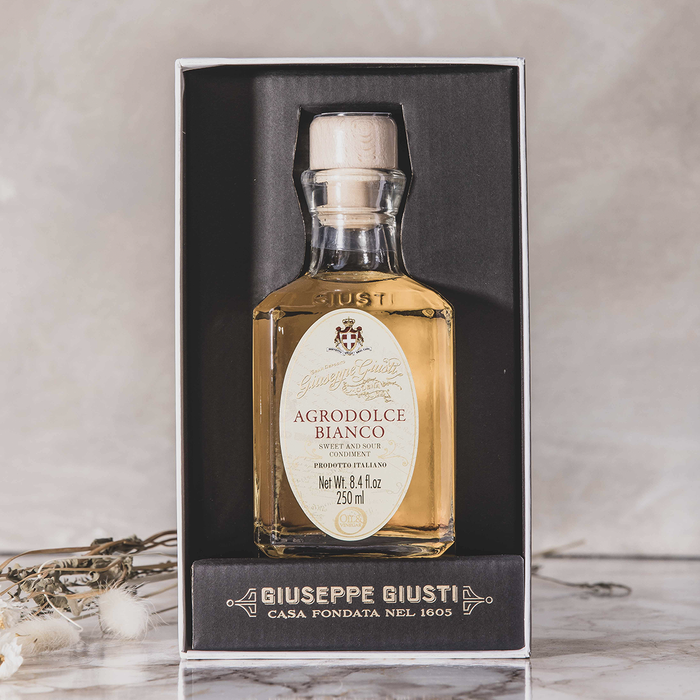 Bottle of white vinegar labeled Agrodolce Bianco in a black box