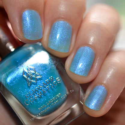 Close-up of nails painted with Ginto Nail Lacquer on fair skin tone. Hand is holding polish bottle.
