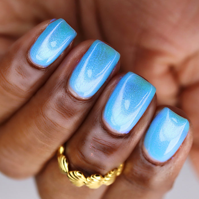 Upside-down, close-up of nails painted with Ginto Nail Lacquer on deep skin tone.