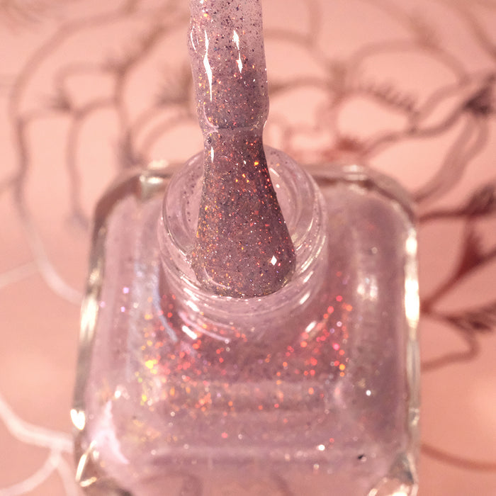 Top-angled, close-up of opened God Speed Nail Lacquer bottle with the brush showing. Emphasizes glitter particles.