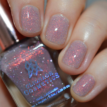 Close-up of nails painted with God Speed Nail Lacquer on fair skin tone. Hand is holding polish bottle.