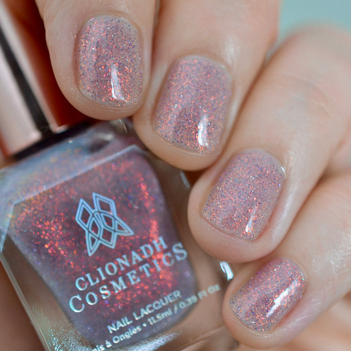 Close-up of nails painted with God Speed Nail Lacquer on fair skin tone. Hand is holding polish bottle.