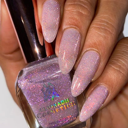 Close-up of nails painted with God Speed Nail Lacquer on medium skin tone. Hand is holding polish bottle.