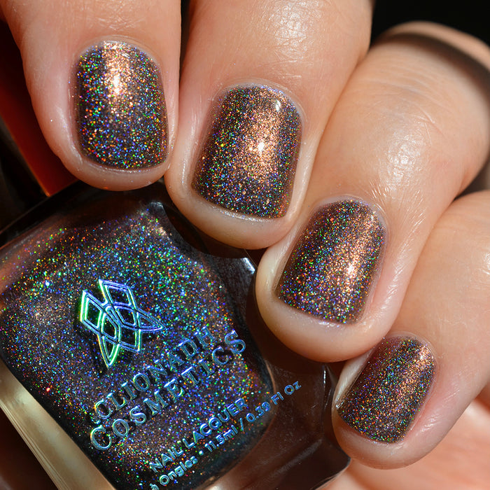 Close-up of nails painted with Graveyard Nail Lacquer on fair skin tone. Hand is holding polish bottle.