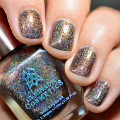 Close-up of nails painted with Graveyard Nail Lacquer on fair skin tone. Hand is holding polish bottle.