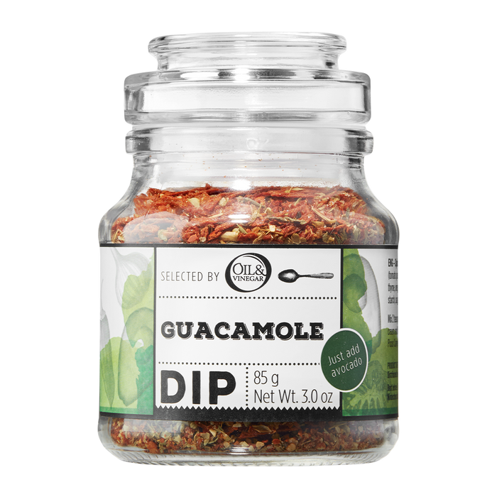 A glass jar containing Guacamole Dip with visible herb mix. The label shows the product name and weight.