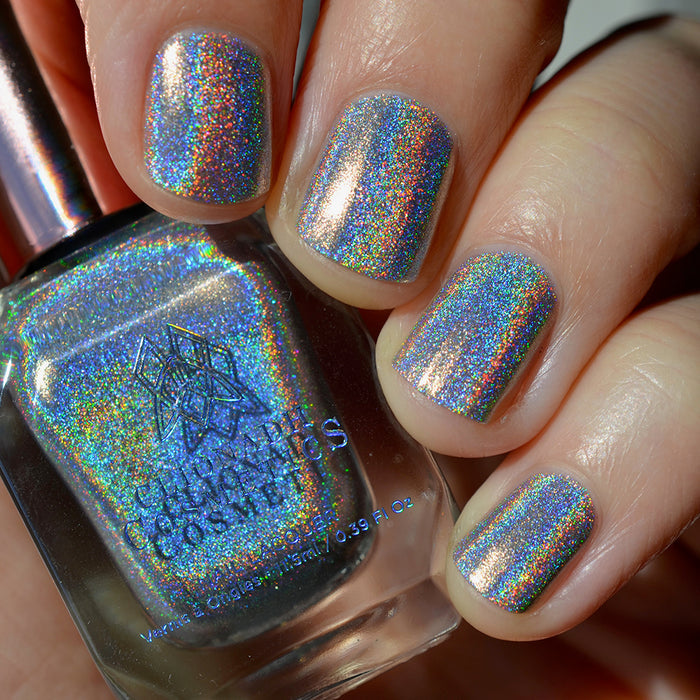 Close-up of nails painted with H₂Olo Nail Lacquer on fair skin tone. Hand is holding polish bottle.