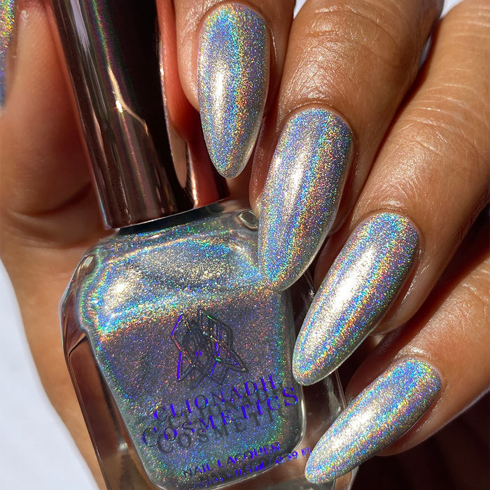 Close-up of nails painted with H₂Olo Nail Lacquer on medium skin tone. Hand is holding polish bottle.