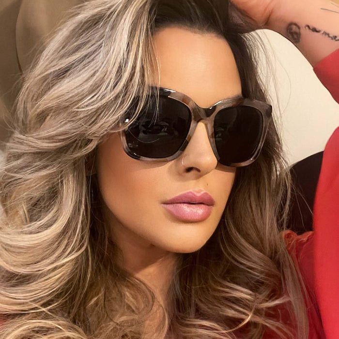 lifestyle - blonde female wearing the hailey in cream tortoise frame and solid grey lenses