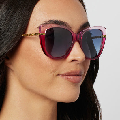 on model - female wearing harry potter x diff eyewear hermione granger 2.0 sunglasses with a ombre pink frame, gold temples and blue bell gradient lenses angled view