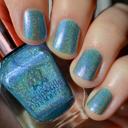 Close-up of nails painted with Holoberry Pie Nail Lacquer on fair skin tone. Hand is holding polish bottle.