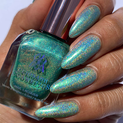 Close-up of nails painted with Holopeño Nail Lacquer on medium skin tone. Hand is holding polish bottle.