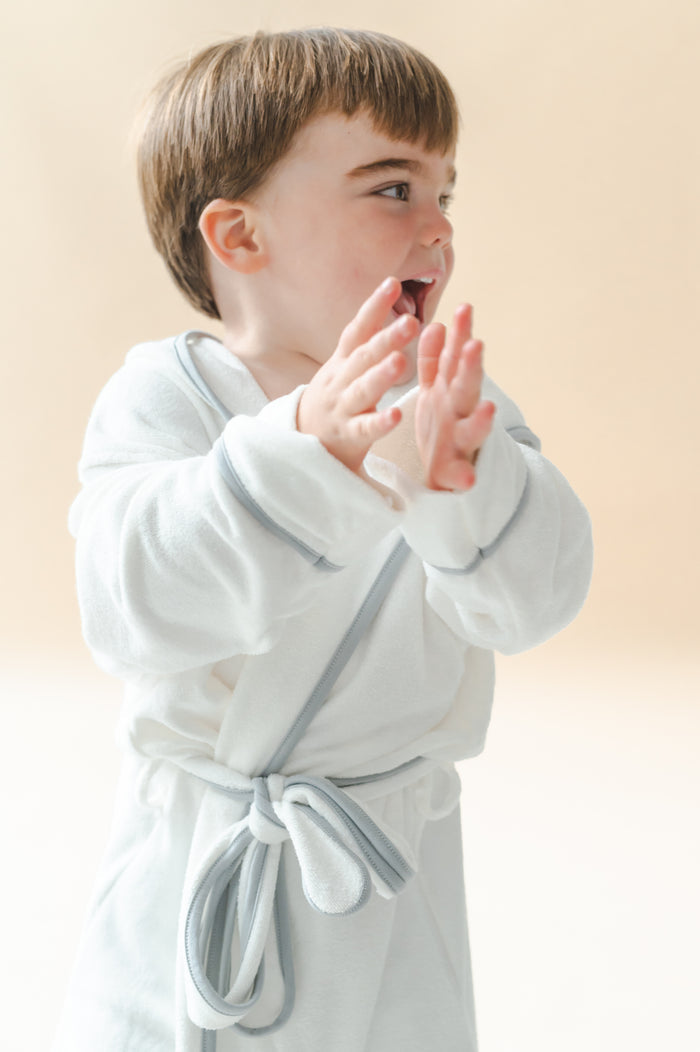 Young boy clapping wearing the Hooded Bath Robe in Cloud with Storm Trim
