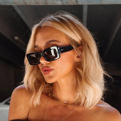 lifestyle  minimally her blonde influencer wearing low profile black sunglasses with dainty gold necklace