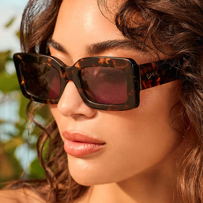 lifestyle - female outdoors wearing diff eyewear indy rectangular sunglasses with a espresso tortoise acetate frame and grey lenses angled view