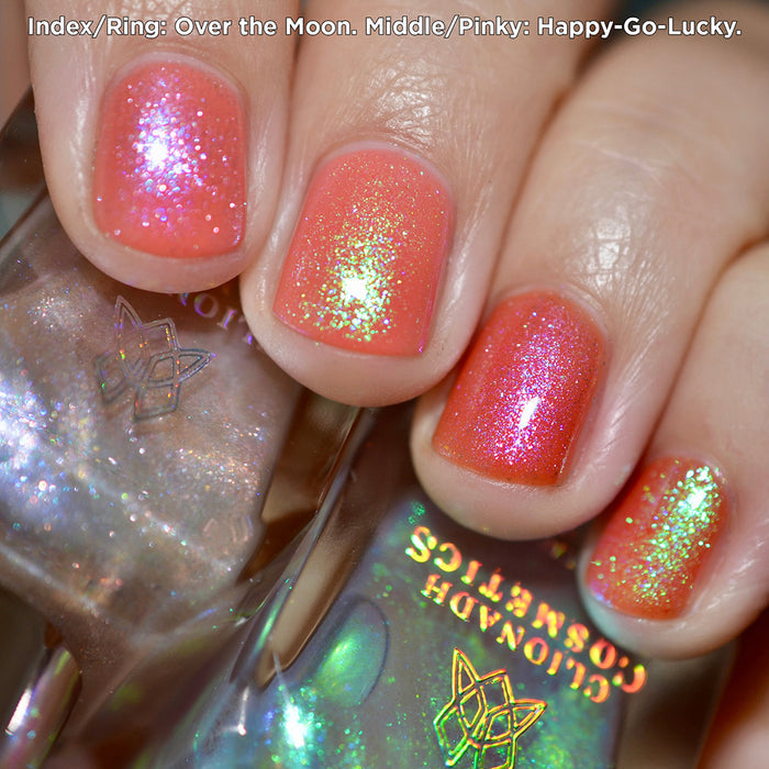 Close-up of nails painted with Over the Moon and Happy-Go-Lucky Nail Lacquers over an orange base on fair skin tone.