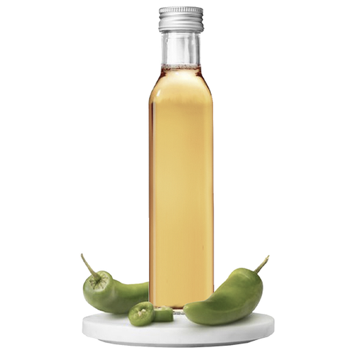 A bottle of Jalapeño Vinegar with whole green jalapeños displayed in front of it.