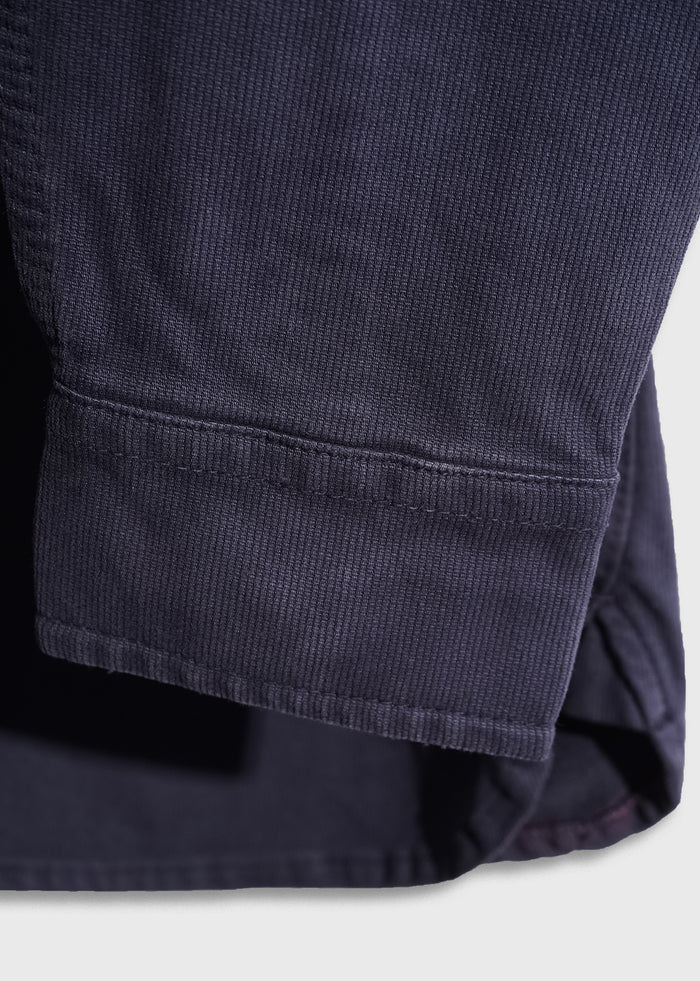 Close-up of a navy blue corduroy fabric sleeve, showcasing its texture and stitching detail against a light background.