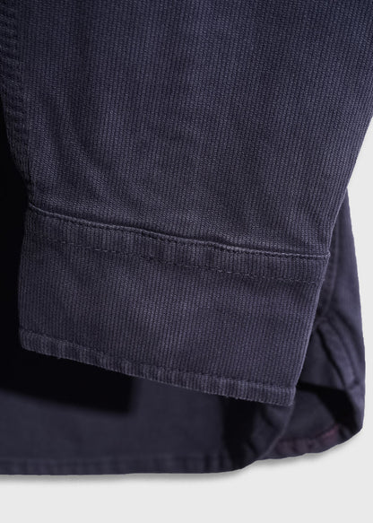 Close-up of a navy blue corduroy fabric sleeve, showcasing its texture and stitching detail against a light background.