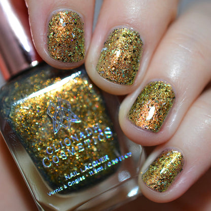 Close-up of nails painted with Kiss Nail Lacquer on fair skin tone. Hand is holding polish bottle.