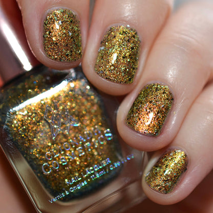 Nails painted with Kiss Nail Lacquer on fair skin tone. Hand is holding polish bottle.