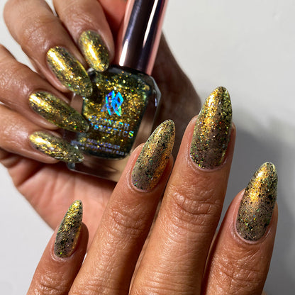 Nails painted with Kiss Nail Lacquer on medium skin tone. Hand is holding polish bottle.