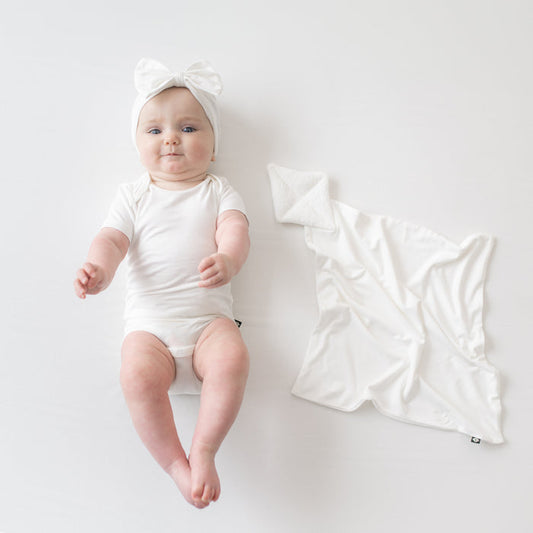 Baby wearing Bow Headband in Cloud  next to Cloud Kite Lovey