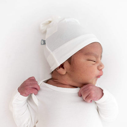 Newborn wearing Kyte Baby Knotted Cap in Cloud white