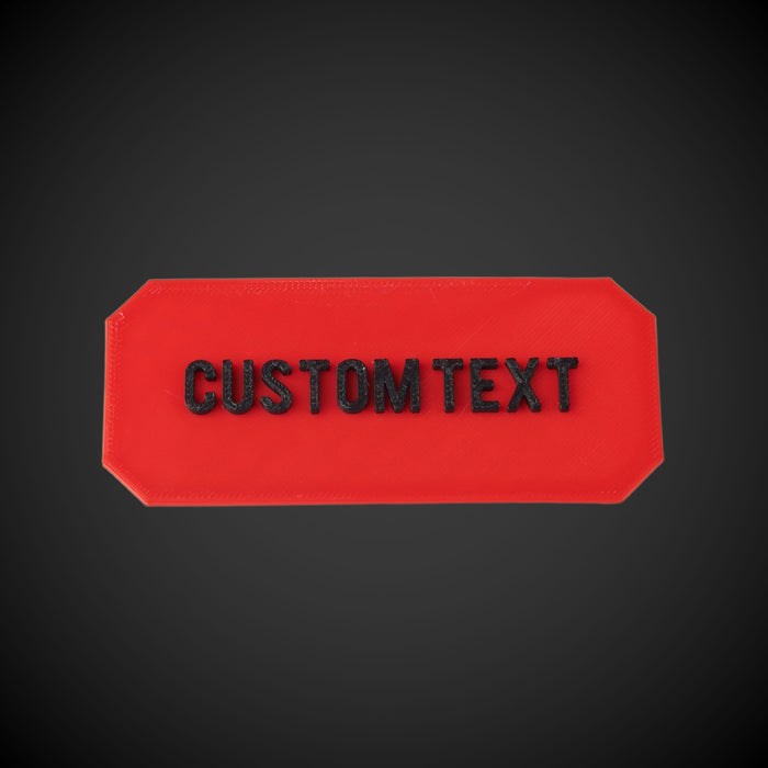 Red rectangular plate with 'CUSTOM TEXT' on a black background