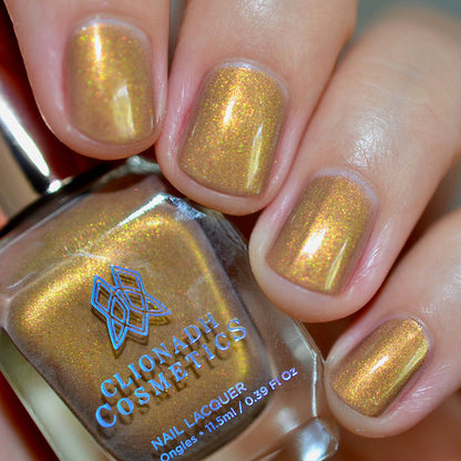 Close-up of nails painted with Lattes and Ciders Nail Lacquer on fair skin tone. Hand is holding polish bottle.