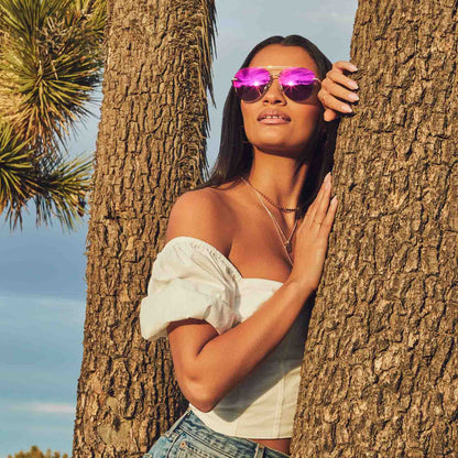 on female model in desert wearing diff eyewear lenox aviator sunglasses with a gold metal frame and sunset mirror polarized lenses