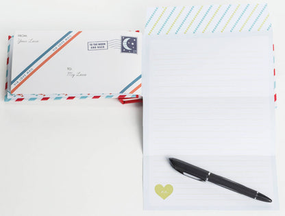 Two stationery items with decorative envelopes and a pen on a white background