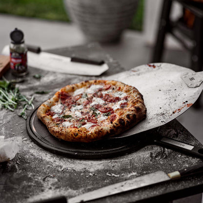 This is an image of pizza being transferred from a Pizza Peel to a Serving Board