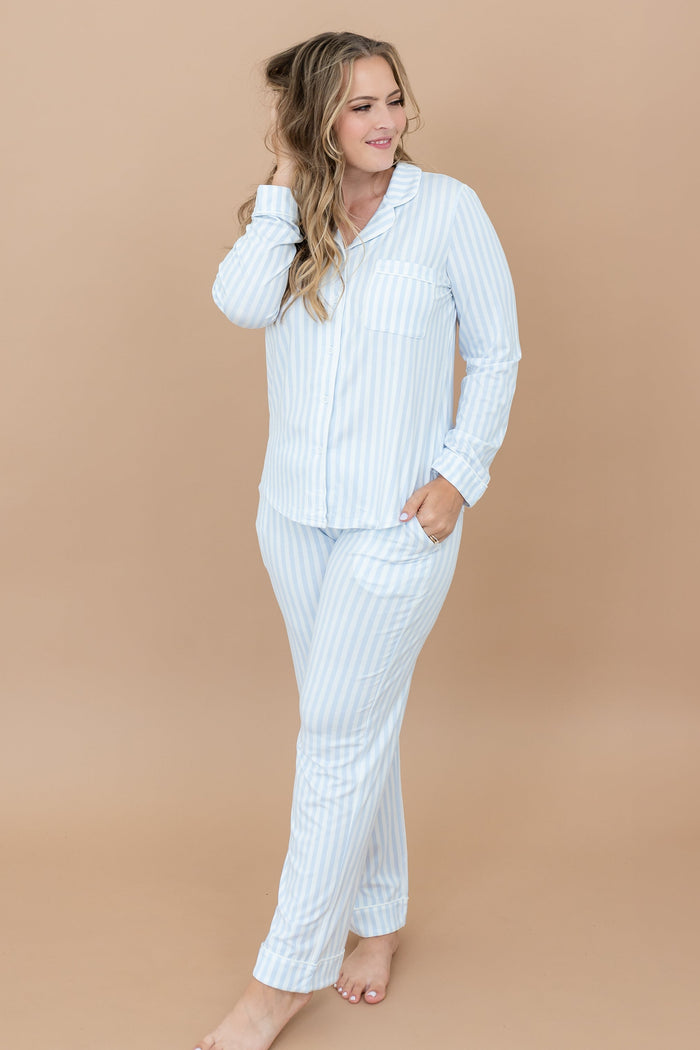 Female model standing with one hand in pants pocket and the other hand in her hair wearing the Long-Sleeved Women's Pajama Set in Small Mist Stripe