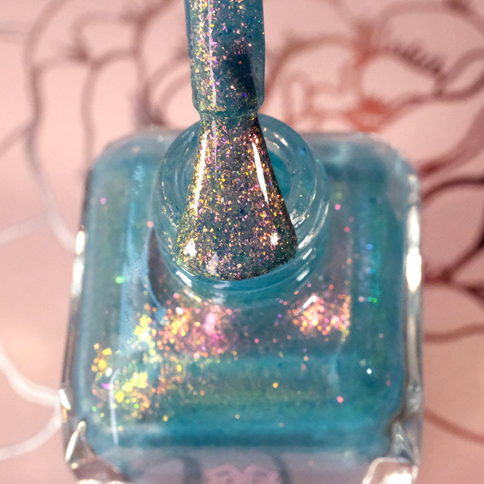 Top-angled, close-up of opened Love Letter Nail Lacquer bottle with the brush showing. Emphasizes glitter particles.