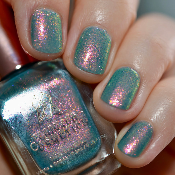 Close-up of nails painted with Love Letter Nail Lacquer on fair skin tone. Hand is holding polish bottle.