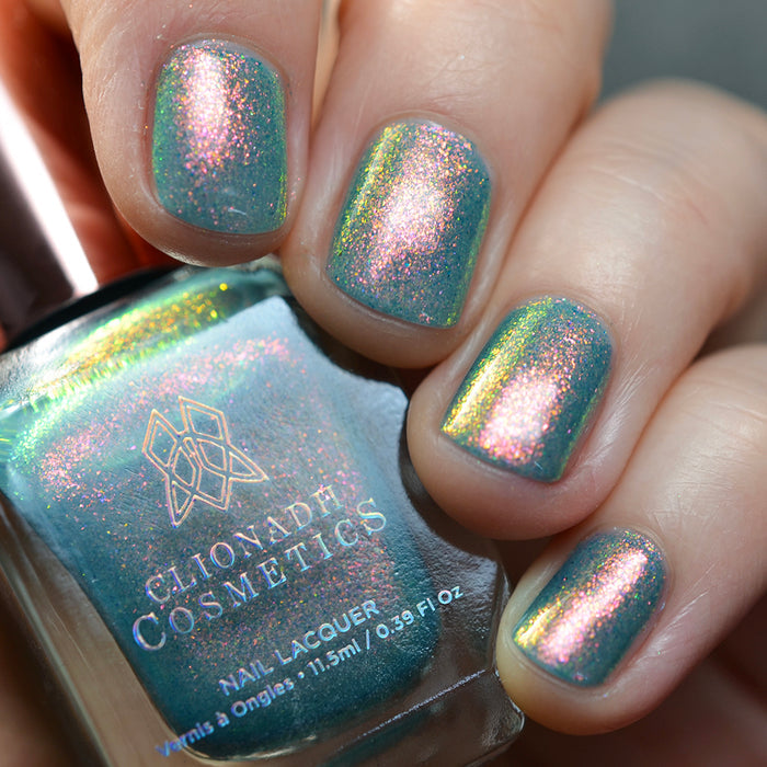 Close-up of nails painted with Love Letter Nail Lacquer on fair skin tone. Hand is holding polish bottle.
