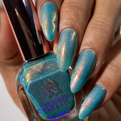 Close-up of nails painted with Love Letter Nail Lacquer on medium skin tone. Hand is holding polish bottle.