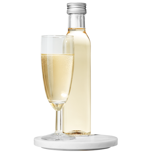 A bottle of Marc de Champagne Vinegar placed next to a filled champagne flute, both resting on a white surface.